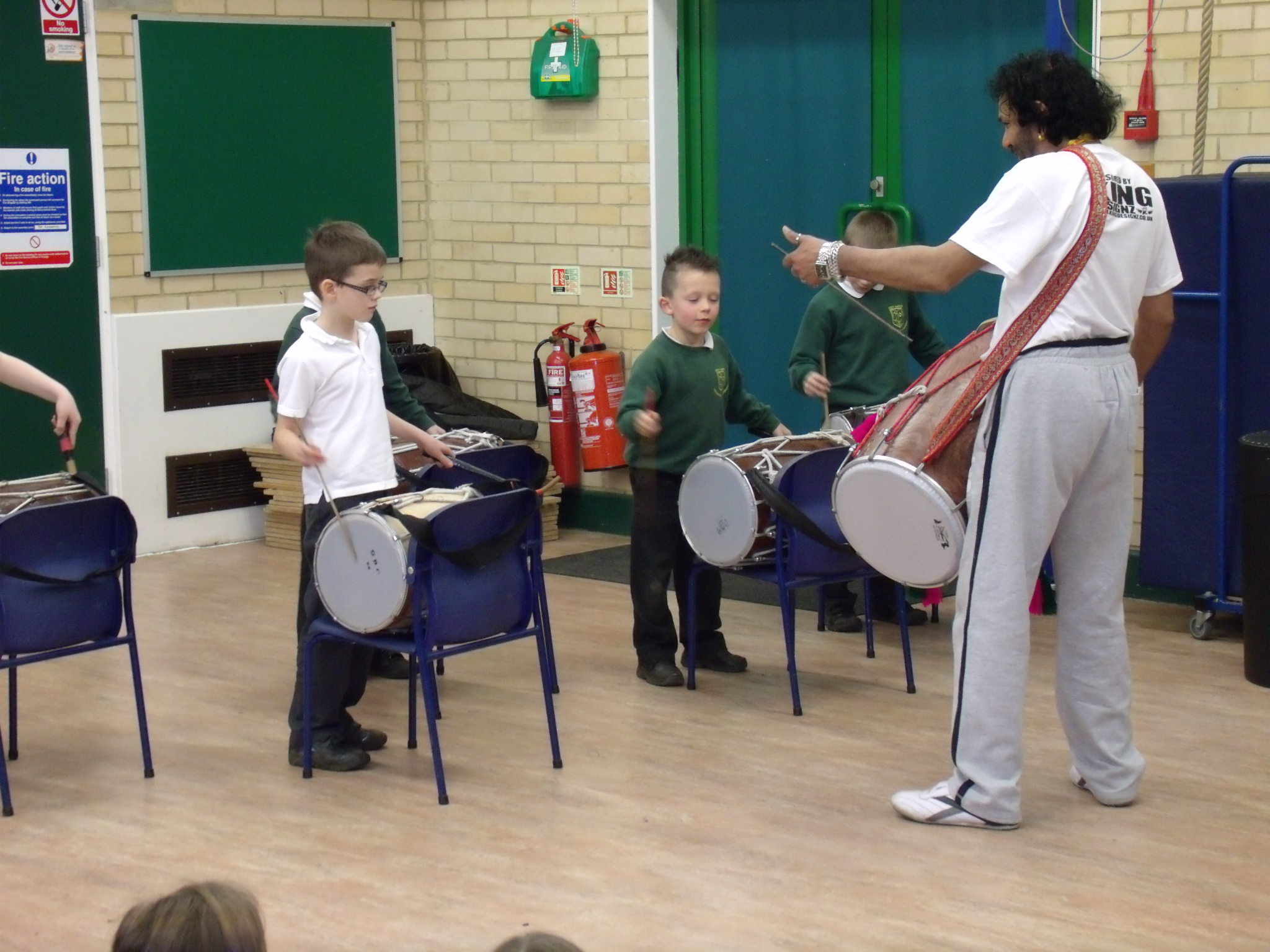 Teacher demonstrating how to play an Indian drum