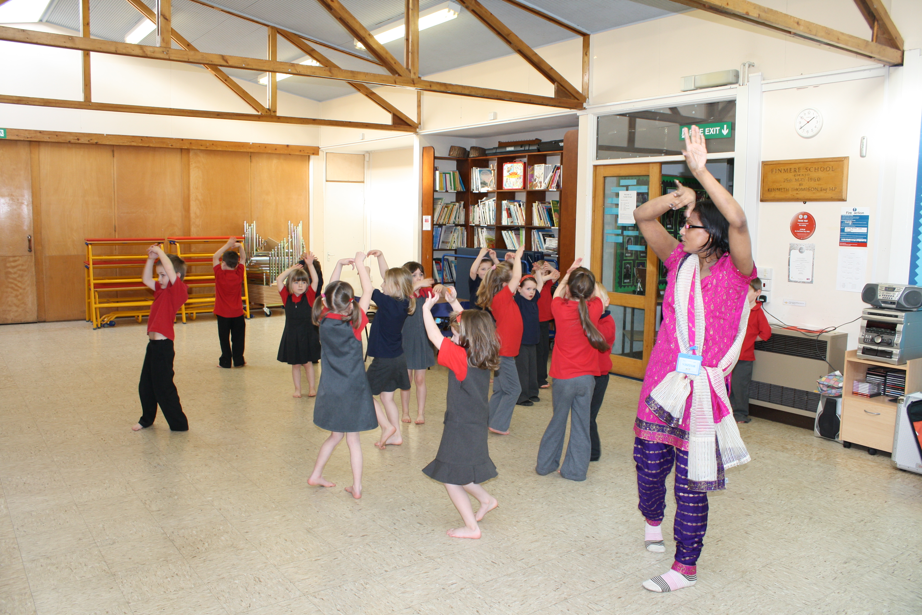 School children dressed in bright Indian clothing learning Indian dance